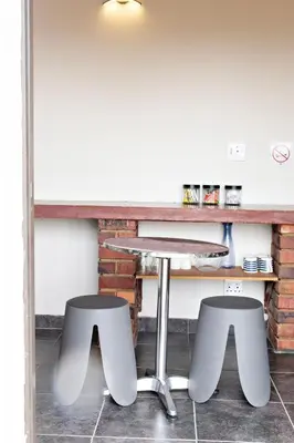 a table and two stools in front of a counter at Pecan and Lime Inn The First Den in Pretoria