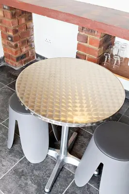 a round table with two chairs and a brick wall at Pecan and Lime Inn The First Den in Pretoria