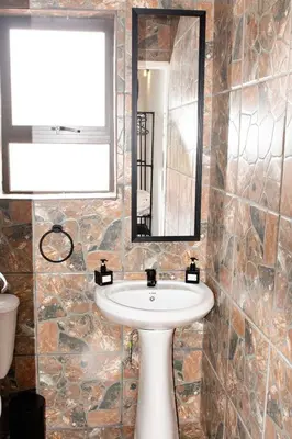 a bathroom with a sink and a mirror at Pecan and Lime Inn The Second Den in Welbekend
