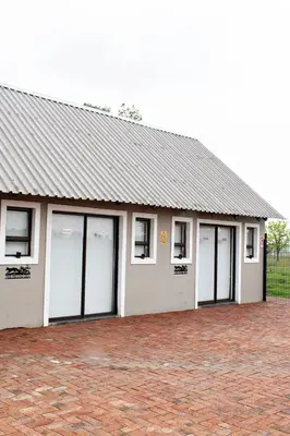 a building with four garage doors and windows at Pecan and Lime Inn The Second Den in Welbekend