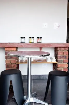 a table and two stools in front of a counter at Pecan and Lime Inn The Second Den in Welbekend