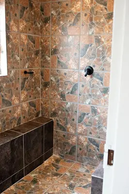 a bathroom with a stone shower with a stone wall at Pecan and Lime Inn The Third Den in Pretoria