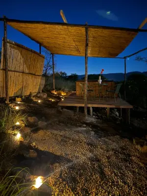 a pavilion with a table and chairs under it at night at Seid Manor Wellness and Healing Retreat in Hartbeespoort