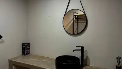 a mirror hanging on a wall above a sink at Seid Manor Wellness and Healing Retreat in Hartbeespoort