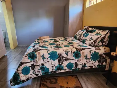 a bed with a quilt on it in a room at El Elyon Lodge in Pretoria