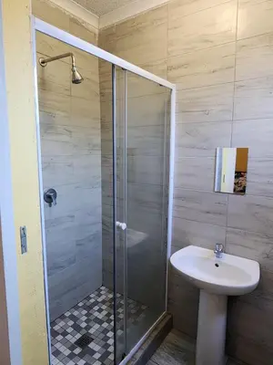 a bathroom with a shower and a sink at El Elyon Lodge in Pretoria