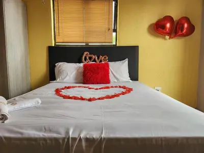 a bed with a heart made out of pillows at El Elyon Lodge in Pretoria