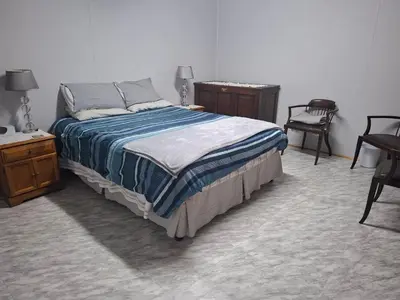 a bedroom with a bed and a table and chairs at AmaZeng farmhouse Mustang in Lydenburg