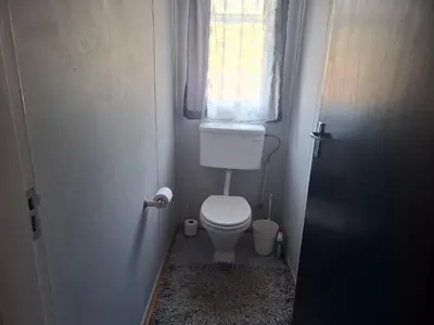 a small bathroom with a toilet and a window at AmaZeng farmhouse Mustang in Lydenburg