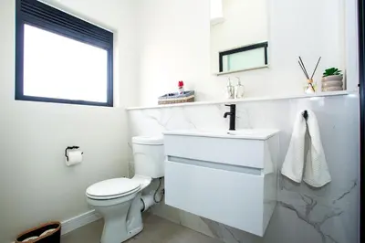a white bathroom with a toilet and a sink at Waterfall Midrand Lifestyle Luxe in Midrand