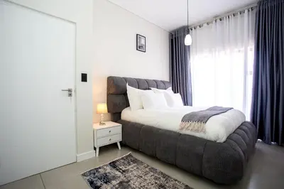 a bedroom with a large bed and a large window at Waterfall Midrand Lifestyle Luxe in Midrand