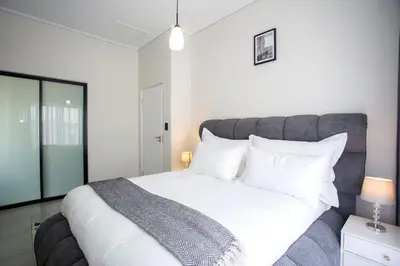 a bedroom with a large bed with white sheets and pillows at Waterfall Midrand Lifestyle Luxe in Midrand
