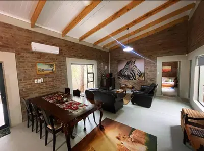 a living room with a table and a dining room at Kudu House-Solar & Water Backup in Marloth Park