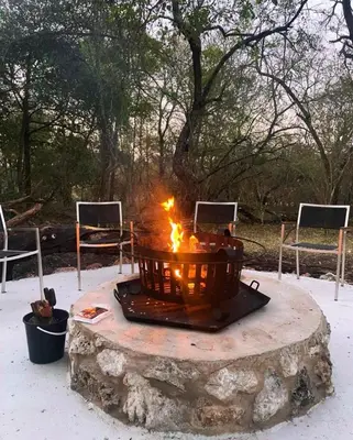 a fire pit sitting on top of a rock at Kudu House-Solar & Water Backup in Marloth Park