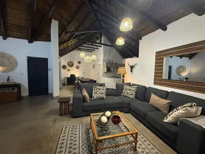 a living room with a couch and a table at Giraffe Bush by J & J in Marloth Park