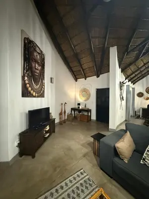 a living room with a couch and a tv at Giraffe Bush by J & J in Marloth Park