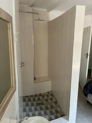 a bathroom with a shower with a toilet at Giraffe Bush by J & J in Marloth Park