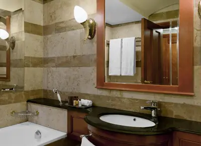 a bathroom with a sink and a mirror and a tub at CT Hotel in Pretoria