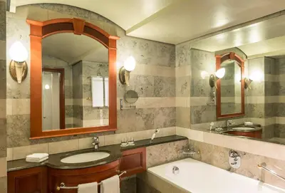 a bathroom with a sink and a tub and a mirror at CT Hotel in Pretoria