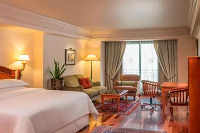 a hotel room with a bed and a living room at CT Hotel in Pretoria