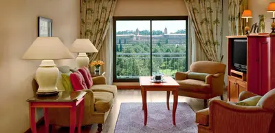 a living room with a couch and chairs and a large window at CT Hotel in Pretoria