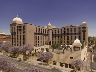 a large building with purple trees in front of it at CT Hotel in Pretoria