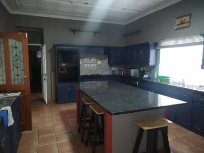 a kitchen with blue cabinets and a counter top at Lady Gray Guest House in Pretoria