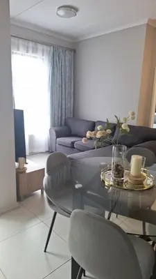 a living room with a couch and a glass table at The Convenient Space in Midrand