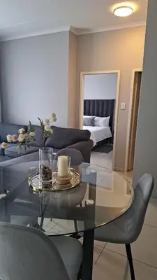 a living room with a couch and a glass table at The Convenient Space in Midrand