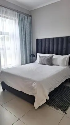 a large bed with a black headboard in a bedroom at The Convenient Space in Midrand