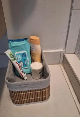a basket with toothbrushes toothpaste and other bathroom items at The Convenient Space in Midrand
