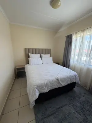 a bedroom with a large bed with white sheets and pillows at Your easy stay OR Tambo in Kempton Park
