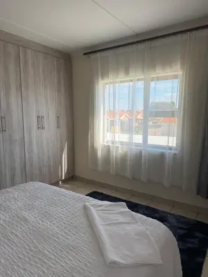 a bedroom with a white bed and a window at Your easy stay OR Tambo in Kempton Park