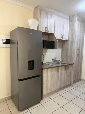 a kitchen with a stainless steel refrigerator and a sink at Your easy stay OR Tambo in Kempton Park