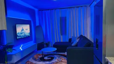 a blue living room with a couch and a table at Your easy stay OR Tambo in Kempton Park