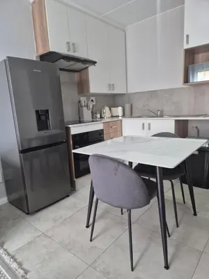 a kitchen with a table and two chairs and a refrigerator at Village Vista at Atlasville 10km from OR Tambo in Boksburg