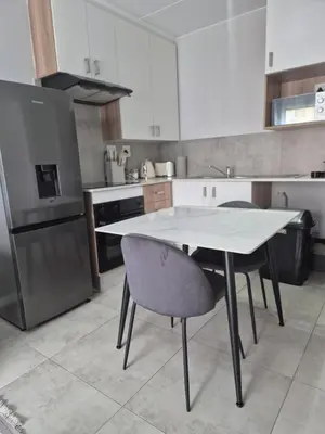 a kitchen with a table and two chairs in it at Village Vista at Atlasville 10km from OR Tambo in Boksburg