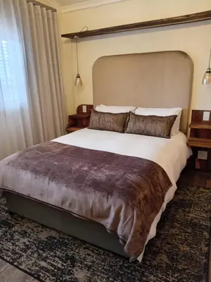 a bedroom with a large bed and a large window at Melkbos Corner in Witbank