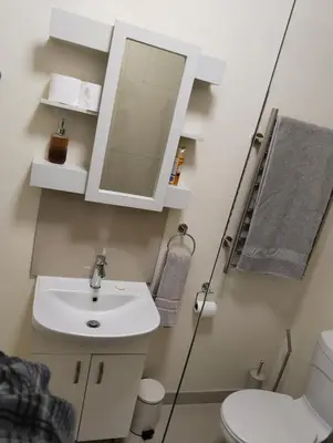 a bathroom with a sink and a mirror at Melkbos Corner in Witbank