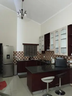 a large kitchen with a counter and a refrigerator at Melkbos Corner in Witbank