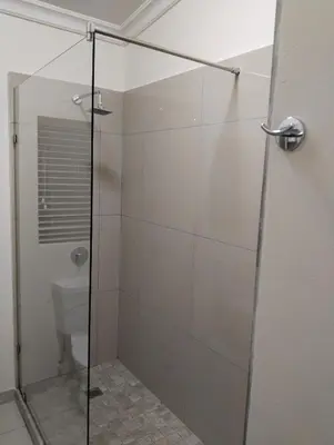 a bathroom with a glass shower with a toilet at Melkbos Corner in Witbank