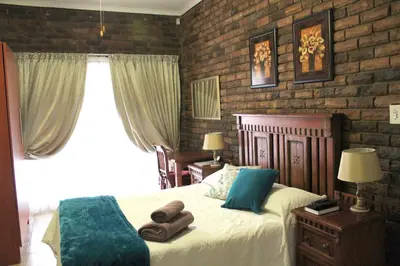 a bedroom with a bed with two towels on it at Steendal Guest House in Polokwane