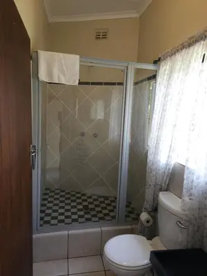 a bathroom with a shower with a teddy bear in it at Steendal Guest House in Polokwane