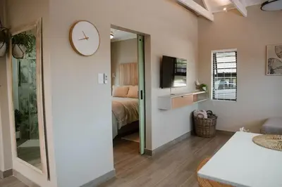 a bedroom with a bed and a clock on the wall at Plekkie Sonder Die See in Centurion