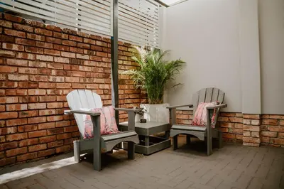 two chairs sitting next to a brick wall at Plekkie Sonder Die See in Centurion