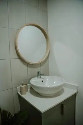 a bathroom with a white sink and a mirror at Plekkie Sonder Die See in Centurion