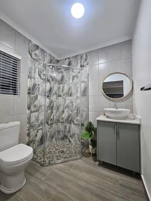 a bathroom with a shower and a toilet and a sink at Plekkie Sonder Die See in Centurion