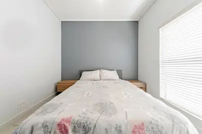 a bedroom with a bed and a window at 2 Bedroom 2 Bathroom Executive Suite in Midrand