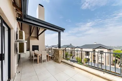 a balcony with a table and chairs on a building at 2 Bedroom 2 Bathroom Executive Suite in Midrand