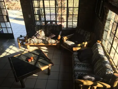 a living room with two couches and a table at Umvangazi Rest in Marloth Park
